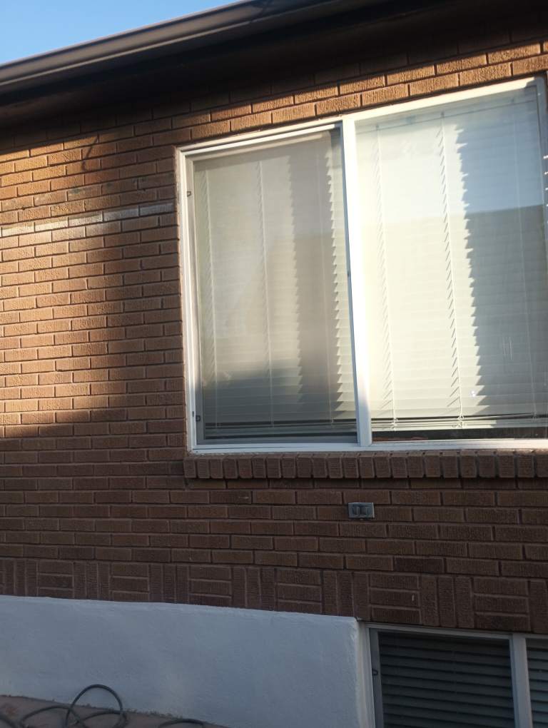 Wide sliding window with custom-fit screen on a residential property